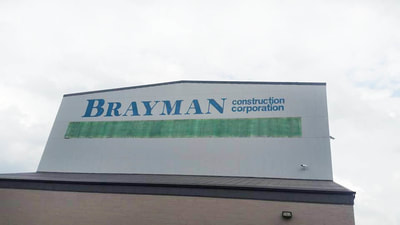 large factory building signage being painted