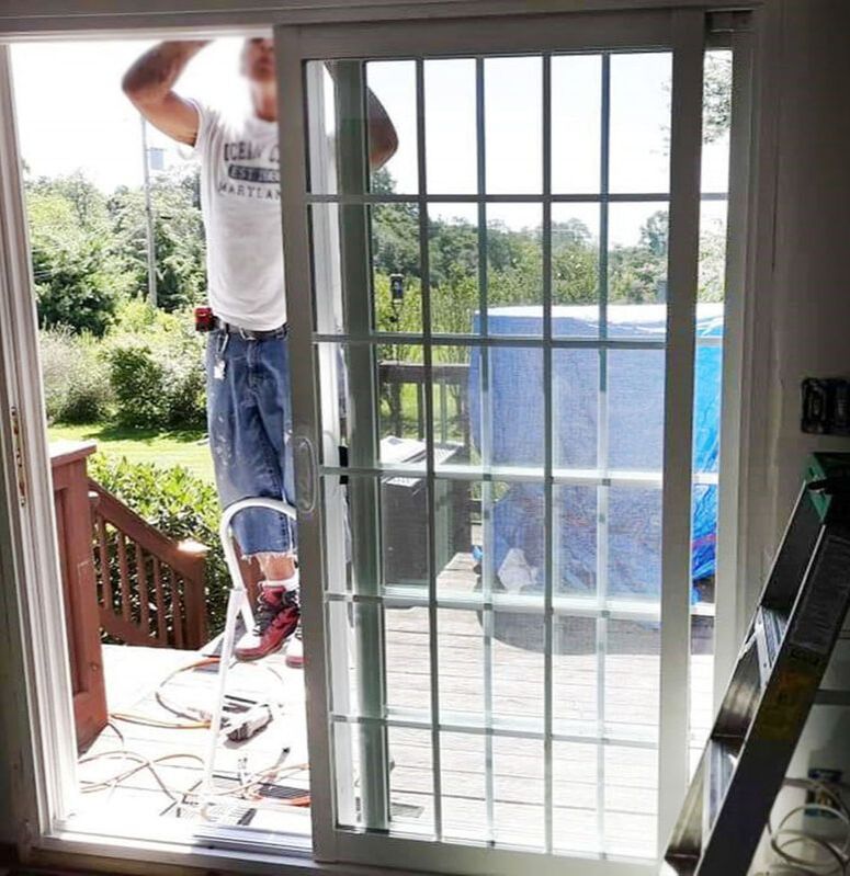 worker installing sliding glass door to patio deck