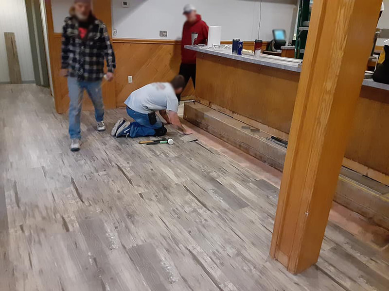 men installing wood laminate flooring