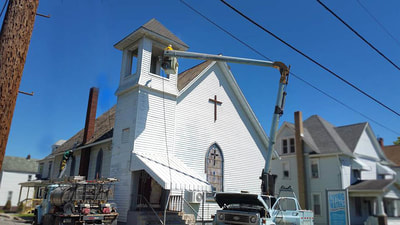 Painting exterior of a church steeple building