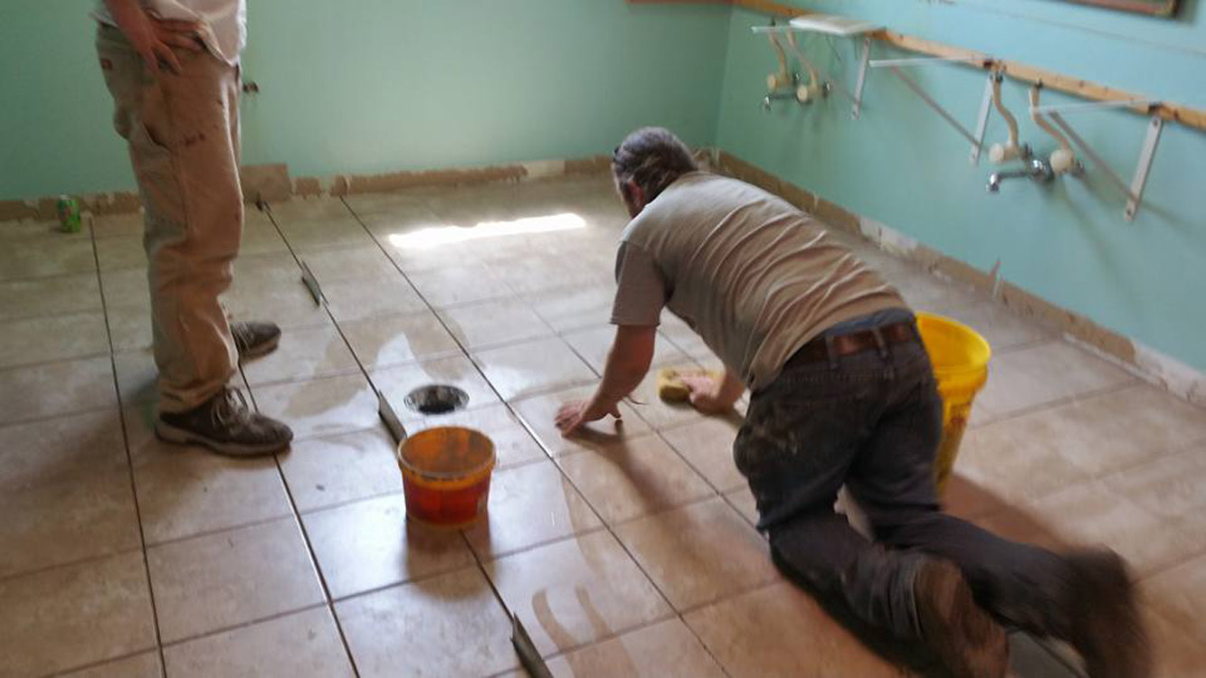 men installing tile flooring