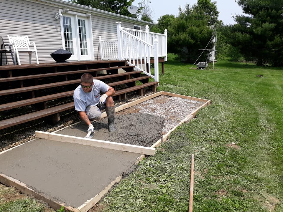 man smoothing the new concrete patio